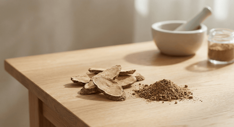Sliced tongkat ali root and ground powder on a wooden table beside a mortar and pestle — testosterone and energy support for men